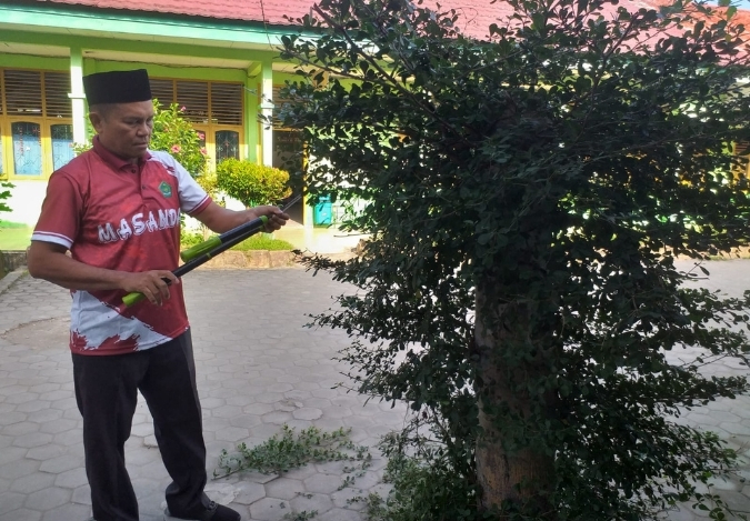 Teladan Hijau: Kepala MTsN 2 Kota Jambi Ikut Rapikan Tanaman Madrasah